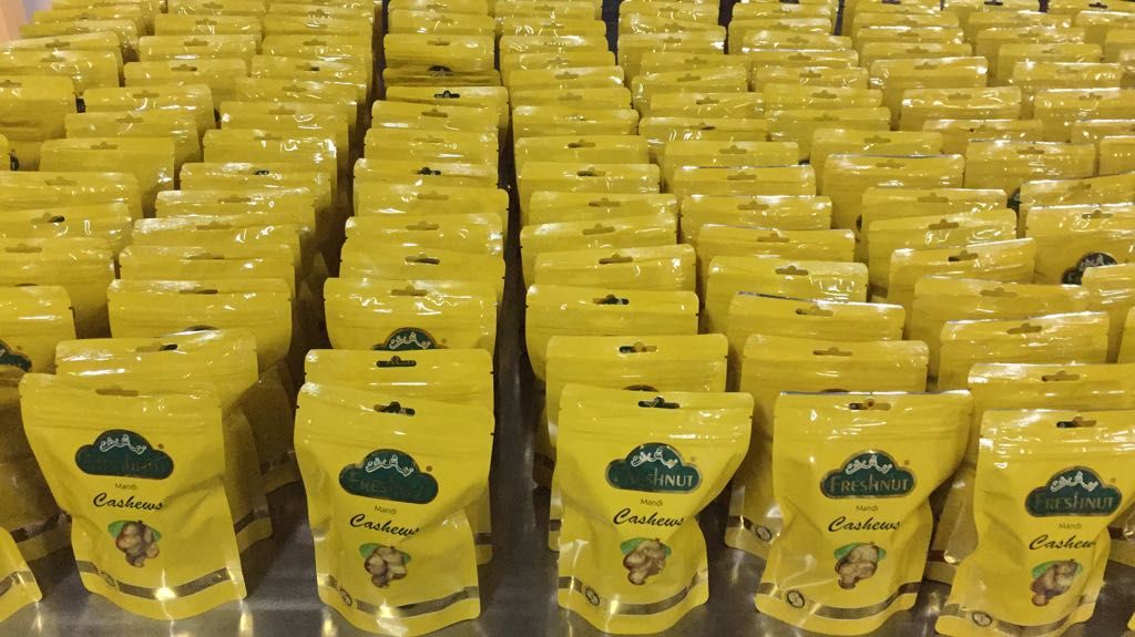 Yellow Mandi cashew pouches on a factory table
